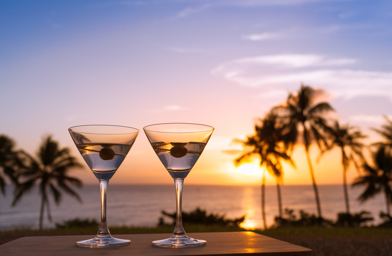 Martini glasses against tropical sunset.
